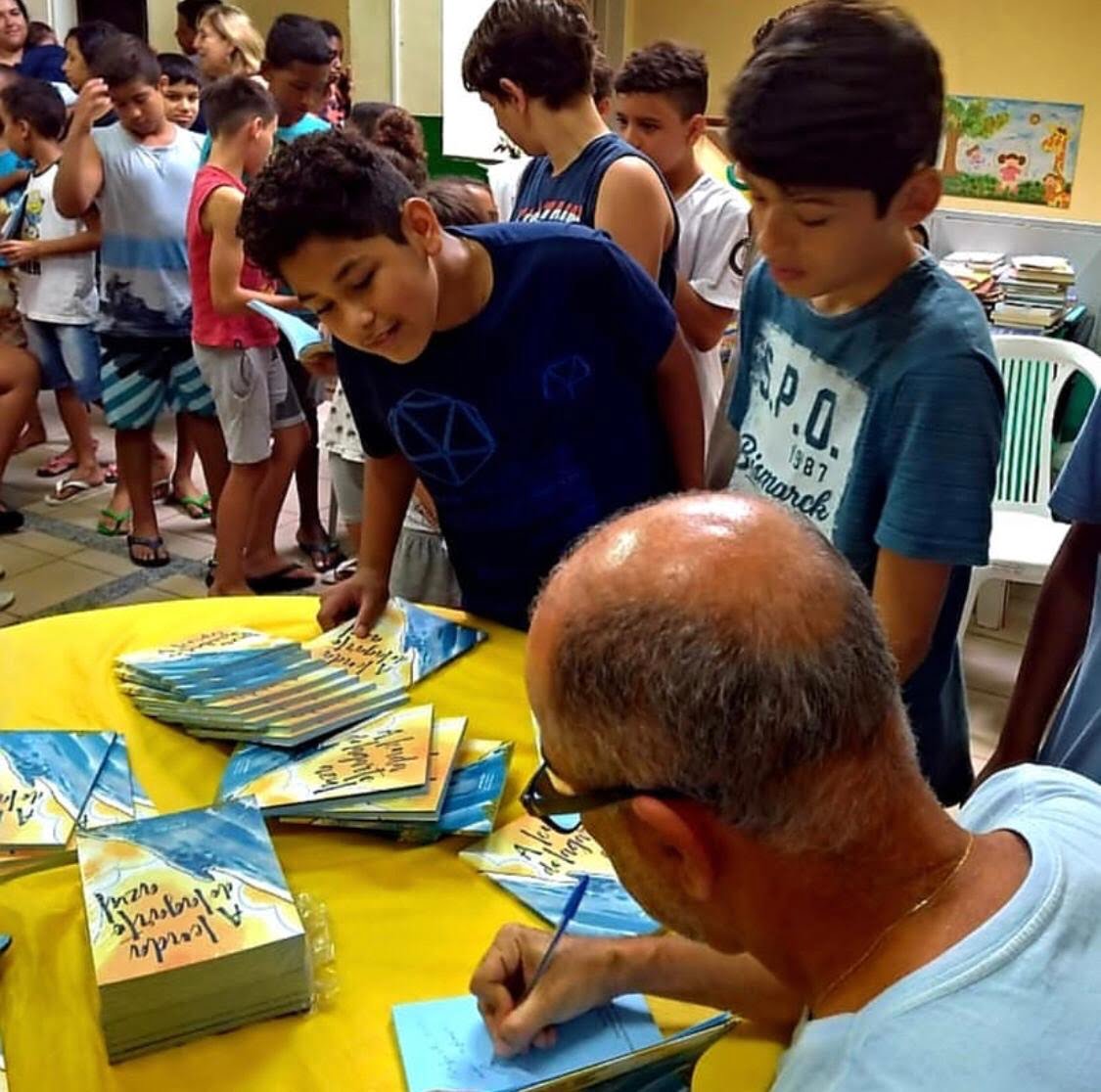 Jonas Reis autografando livros.